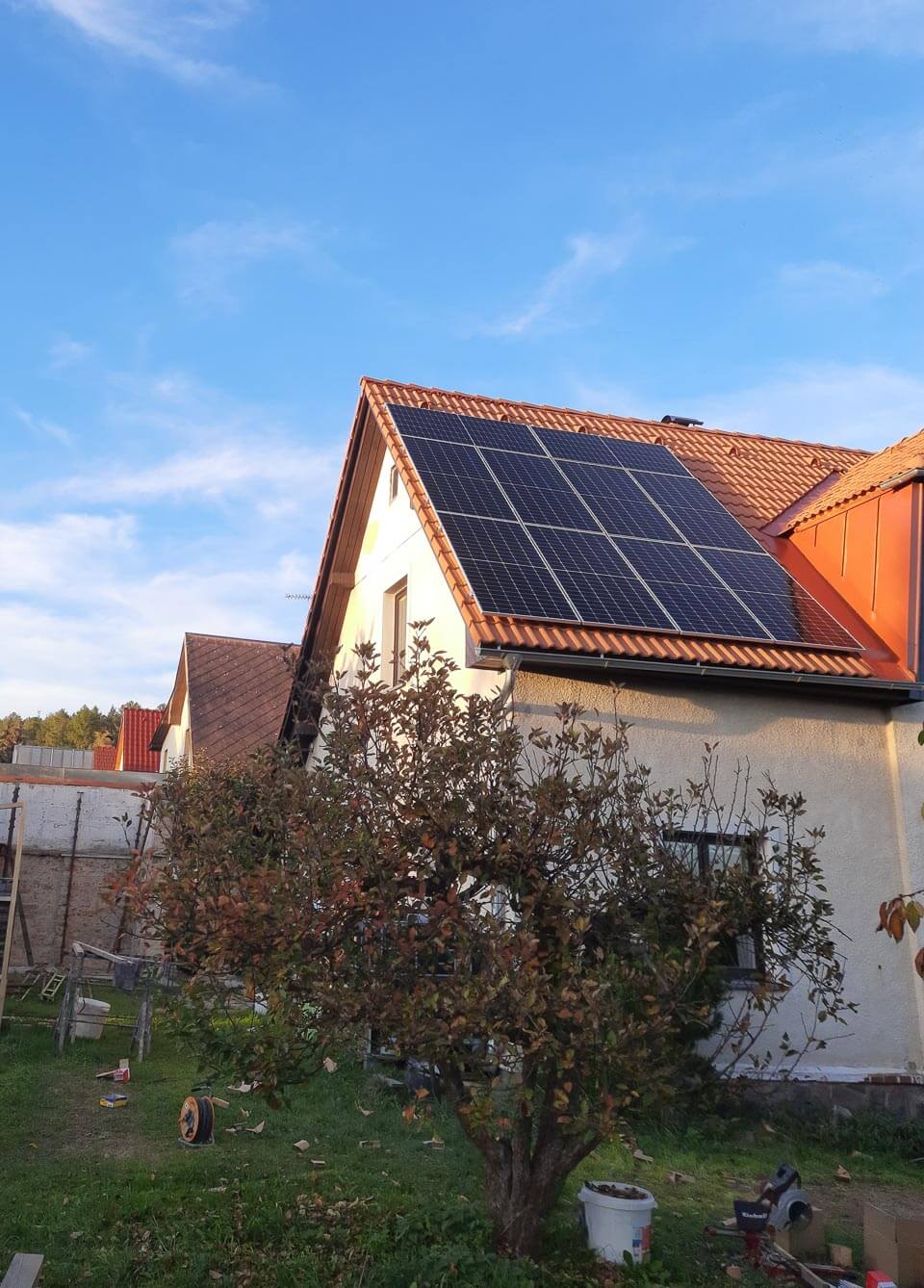 Rodinný dům s fotovoltaikou na střeše při západu slunce